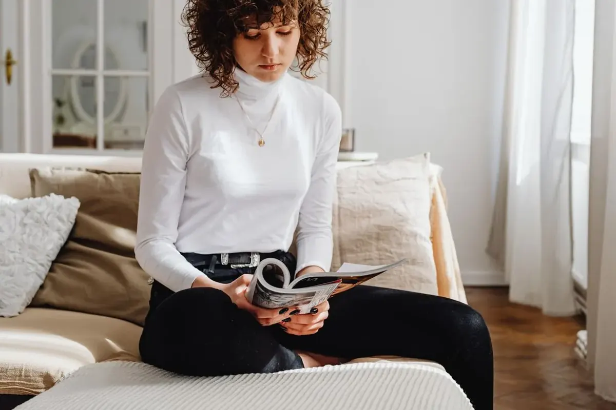 Une lectrice consulte un magazine dans son salon, illustration d’un abonnement Ça m'intéresse